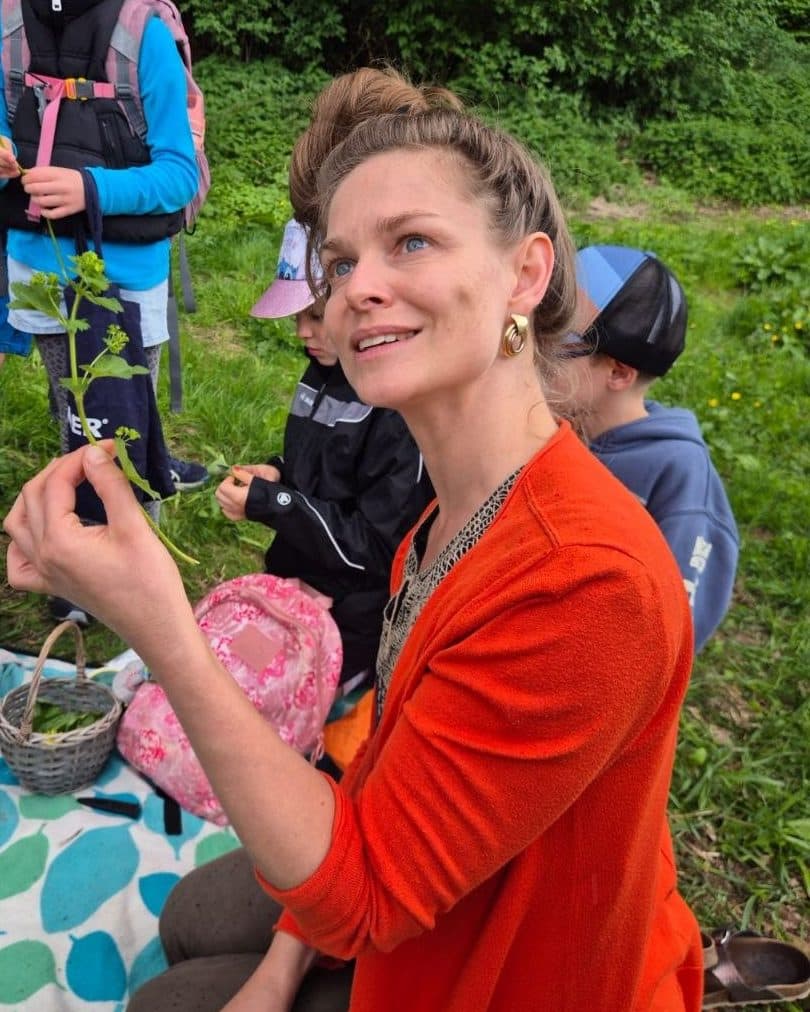 Ariane zeigt bei einer Kräuterwanderung ein frisch gepflücktes Kraut